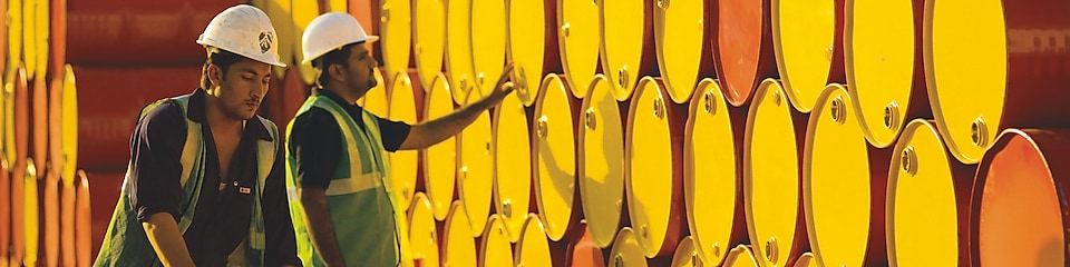 two employees transporting Shell barrels