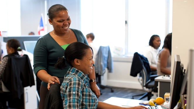 two women smiling looking at computer