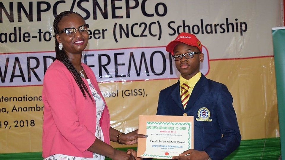 Woman presenting award to a boy