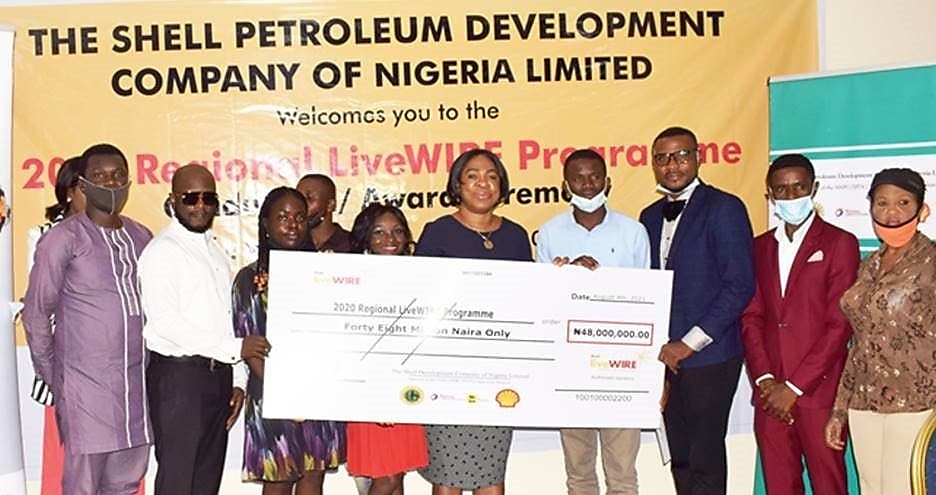 Social Performance and Social Investment Manager, The Shell Petroleum Development Company of Nigeria Limited, Dr. Gloria Udoh (middle), presenting a N48m cheque to representatives of the 117 beneficiaries of the Shell Nigeria LiveWIRE programme at a graduation ceremony in Port Harcourt.